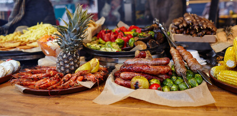 Christmas street food festival on fair in town center, winter holidays. Bbq street food for sale, delicious sausages on holiday street market in european city
