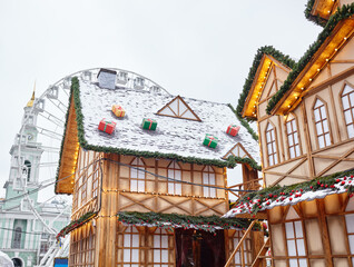 Obraz premium The roof of House Decorated for the Christmas in Europe city. Facade of house for the Christmas Holidays against the backdrop of a ferris wheel
