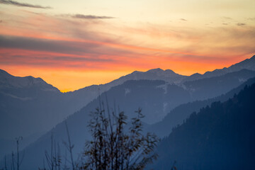 Sunrise sunset dusk dawn colors over the himalaya mountains with fog haze in distance with rich...