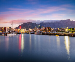 Obraz premium Waterfront and cape town city lights at dusk with table mountain in the background, Cape Town, South Africa