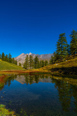 Obraz premium Spettacolo in Valle Varaita: dalla vetta del monte Peyron con vista sul Lago di Pontechianale e sulla cima del Monviso