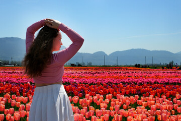 A girl playing in a flower garden with rainbow