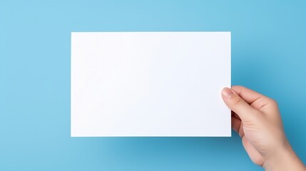 Obraz premium hand holding white blank paper isolated on blue background : Generative AI