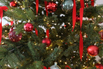 Decorative Christmas tree with red toys and ribbons