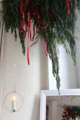 garland of fir branches under the ceiling against a white wall