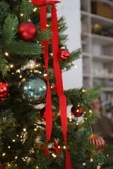 Decorative Christmas tree with red toys and ribbons