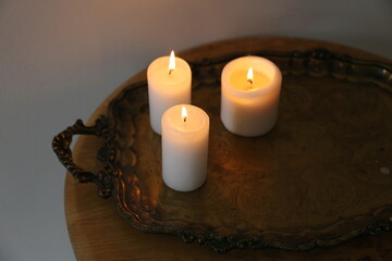 White burning candles in boho room