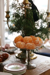 vase with peeled tangerines on a table decorated for Christmas