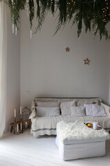 garland of fir branches to the ceiling in a room with a sofa