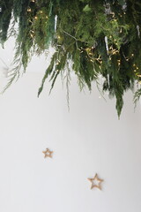 garland of fir branches under the ceiling against a white wall