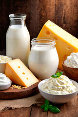 Dairy organic products. Milk, cheese, sour cream, cottage cheese, yogurt and butter on a wooden background in a rustic style.