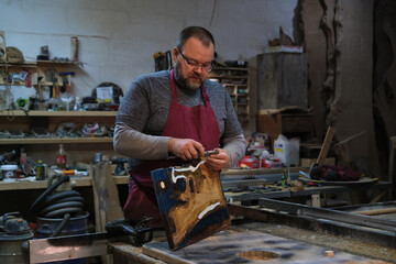 A craftsman planes a wooden piece; focus in his eyes. Echoes the trend of mindfulness in manual...