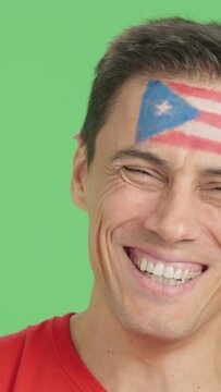 Man with a puerto rican flag painted on the face smiling