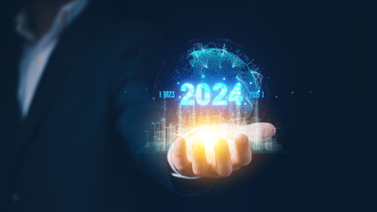2024 business world concept. Businessman holding Holographic City and Global network connection. New year business startup and Goals target. Networks and technology to increase profits in 2024.