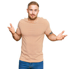 Young irish man wearing casual clothes clueless and confused expression with arms and hands raised. doubt concept.