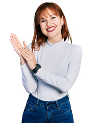 Redhead young woman wearing casual turtleneck sweater clapping and applauding happy and joyful, smiling proud hands together