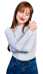 Redhead young woman wearing casual turtleneck sweater hugging oneself happy and positive, smiling confident. self love and self care