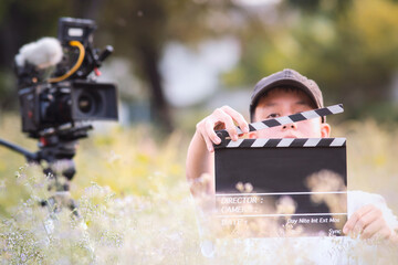 Teenage boy holding a film slate or film clapper board in the movie industry. new content creator,...