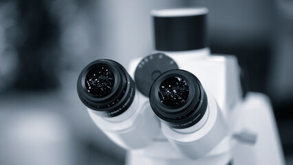 Eyepiece of a laboratory microscope in blue. Two black microscope eyepieces for examining...
