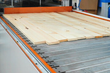 Wood boards on a woodworking machine in a modern furniture factory, woodworking industrial concept...