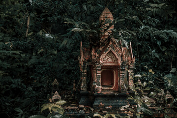 A beautiful little abandoned temple in the jungle. Green leaves. Ancient architecture of Asia.