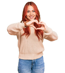 Young redhead woman wearing casual winter sweater smiling in love doing heart symbol shape with...