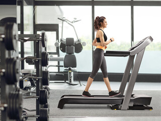 Fototapeta na wymiar Woman walking on a treadmill at the gym