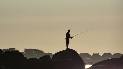 L’homme qui pêche seul sur son rocher - obrazy, fototapety, plakaty