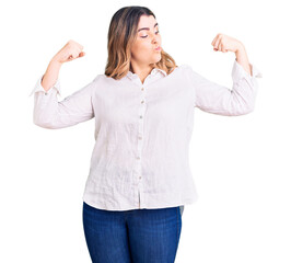 Young caucasian woman wearing casual clothes showing arms muscles smiling proud. fitness concept.