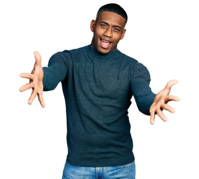 Young black man wearing casual sweater looking at the camera smiling with open arms for hug. cheerful expression embracing happiness.