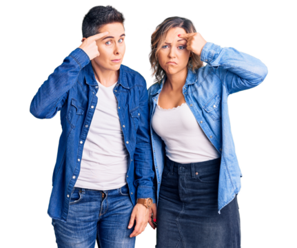 Couple of women wearing casual clothes pointing unhappy to pimple on forehead, ugly infection of blackhead. acne and skin problem