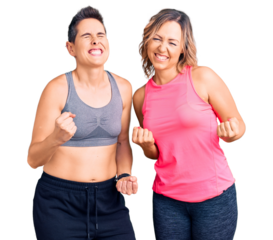 Couple of women wearing sportswear very happy and excited doing winner gesture with arms raised, smiling and screaming for success. celebration concept.