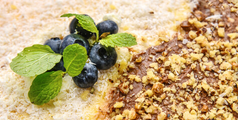 Cake with nuts, milk chocolate, blueberry and mint leaves