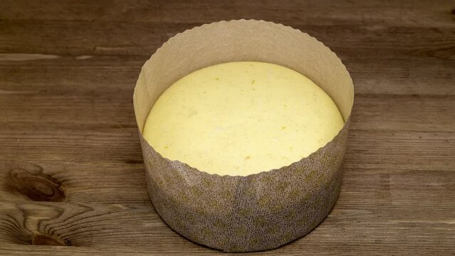 panettone dough rising in a proofing wooden basket.