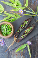 Aubergine cuisin&eacute;e &agrave; la japonaise sur une ardoise accompagn&eacute; d'un pot de ciboulette