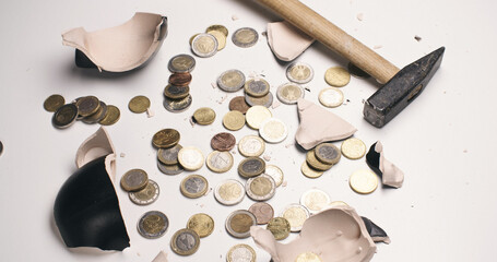 Concept photo with a broken piggy bank and scattered coins