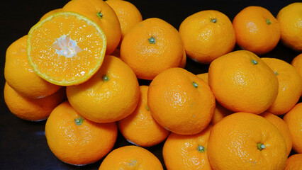 1個だけ真横にカットされたみかんと、テーブルに並べられた20個のみかん(ややアップ)　2078