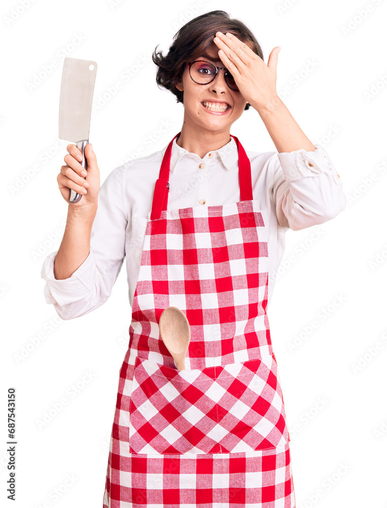 Sticker beautiful young woman with short hair wearing professional baker apron holding knife stressed and fr