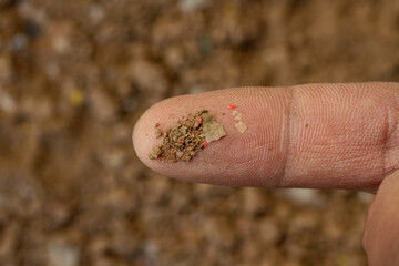 Soil pollution, microplastic contamination in the soil on geologist's finger