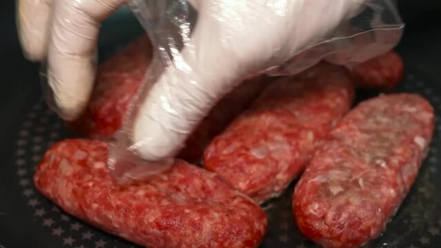 Process of frying minced meat cutlets in the form of lula kebabs, served on bamboo skewers on a wooden board.