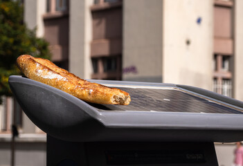A discarded piece of bread - a French baguette - on the solar cells of a road device in Grenoble