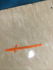 Tiny Plastic Sword Shaped Drink Stirrer On Tile Floor