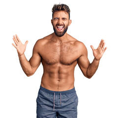 Young hispanic man wearing swimwear shirtless celebrating mad and crazy for success with arms...