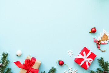 Christmas composition or greeting card. Christmas present box, candle and decorations at blue. Flat lay image with copy space.