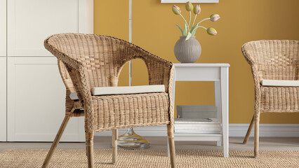 Closeup of rattan woven armchairs with white cushions in a yellow room. - obrazy, fototapety, plakaty