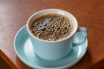 Coffee black in a cup over natural light