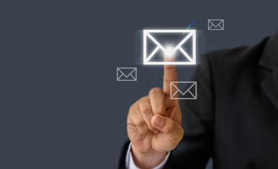 Communication concept: Businessman hand pressing a letter or email icon , world wide technology.