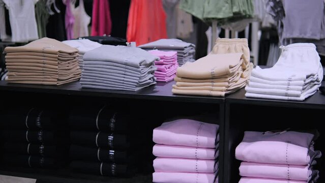 Neatly stacked clothes displayed in store. Womens department has large selection of comfortable clothes for daytime wear. Choosing clothes can be pleasant leisure in supermarket with large assortment