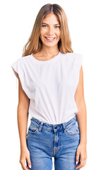 Fototapeta premium Beautiful caucasian woman with blonde hair wearing casual white tshirt with a happy and cool smile on face. lucky person.