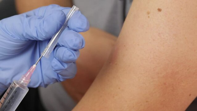 m&eacute;decin faisant une piqure au bras d'un patient